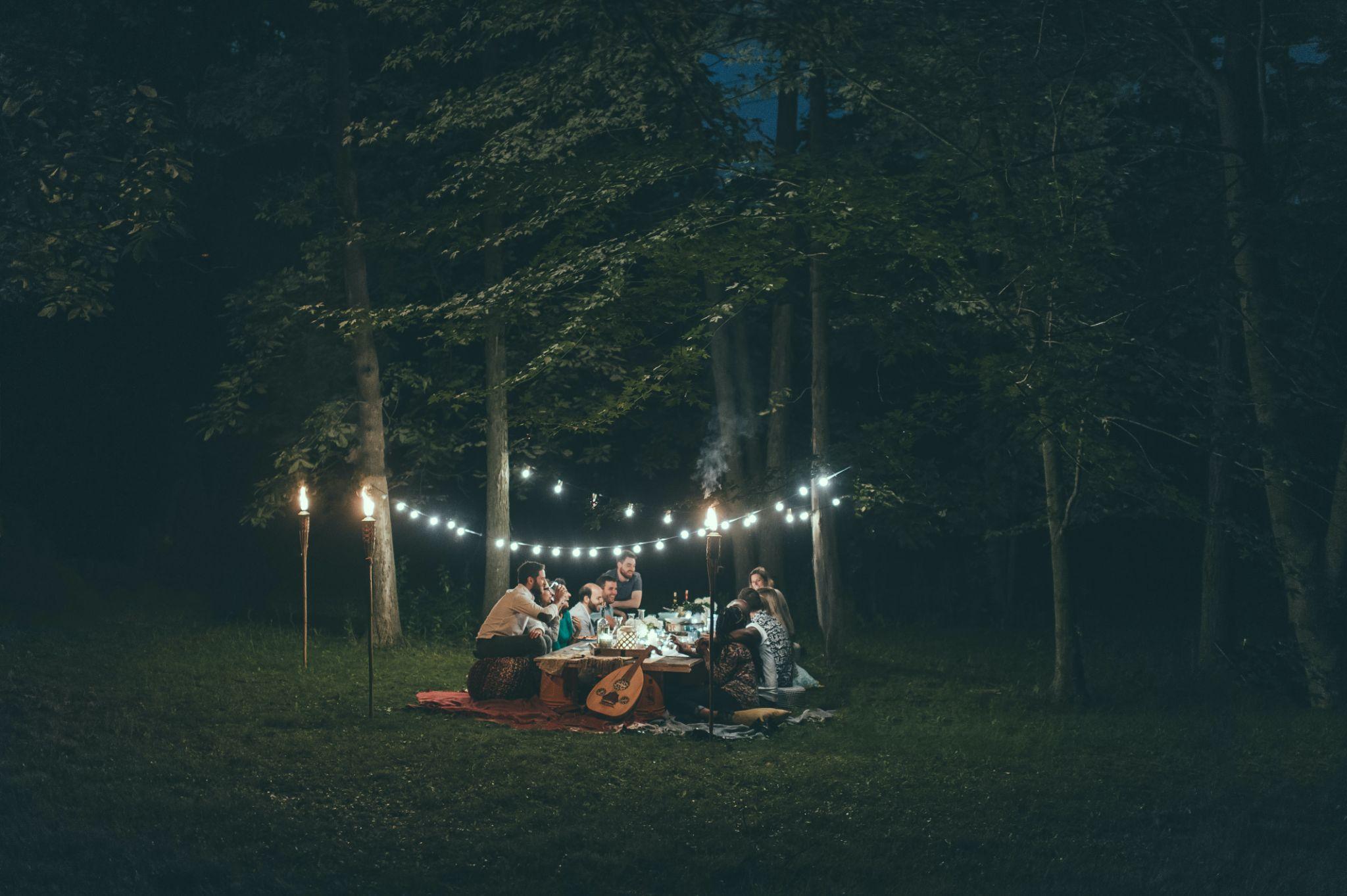People hanging out for movies and dinner in the woods