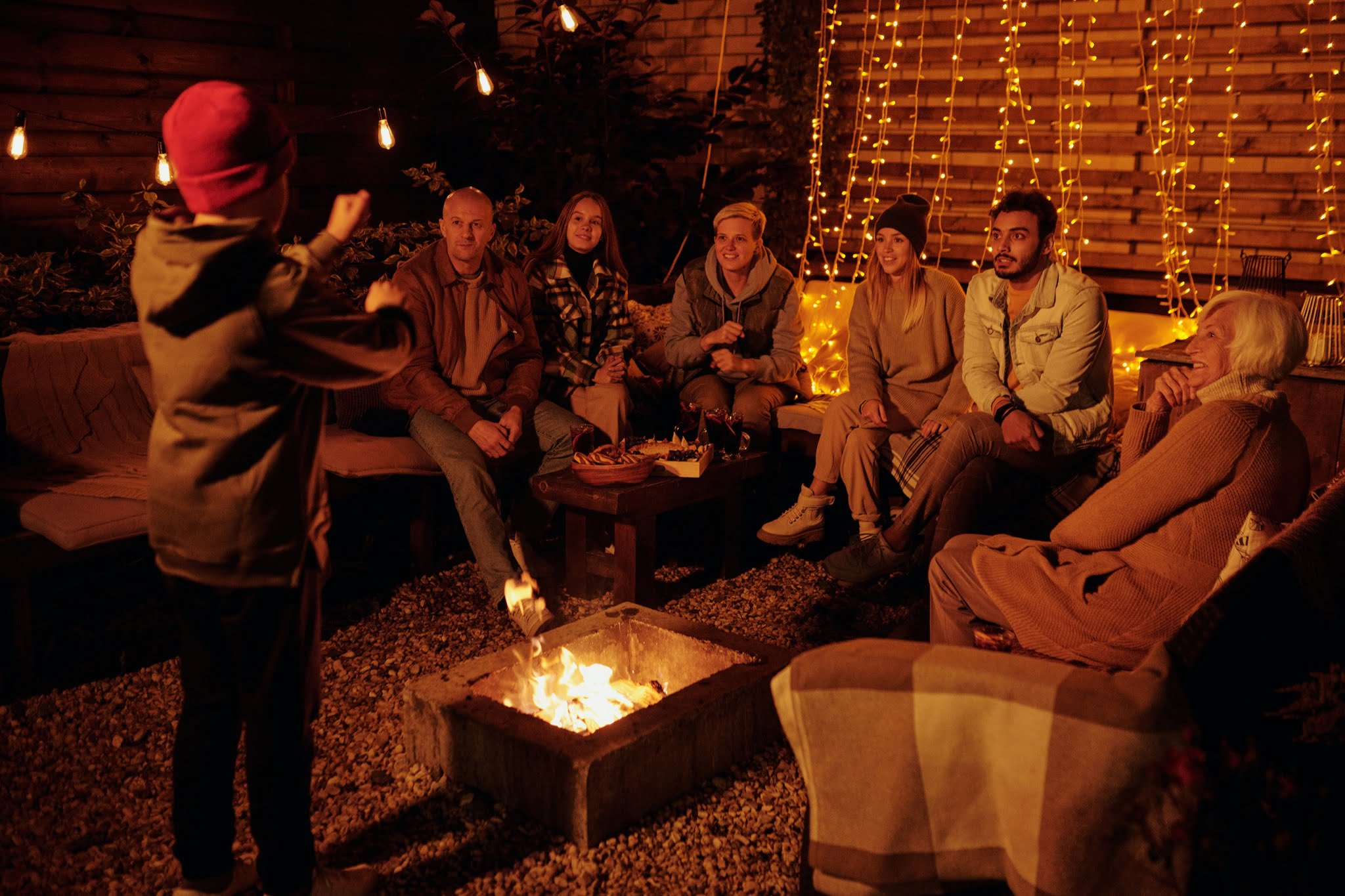 a group of friend surrounding bonfire
